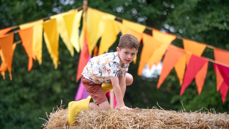 A child climbs Strawton Castle in the play meadow at Stourhead